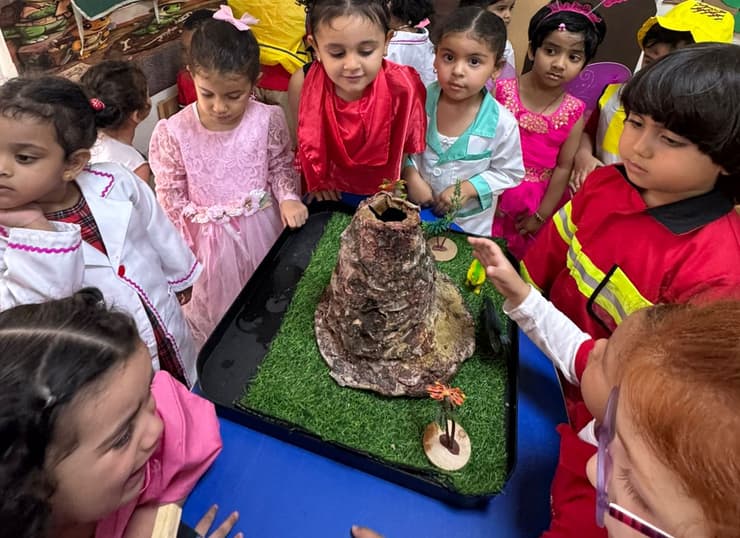 Children gathered around a nature display in the classroom at Little Regent
